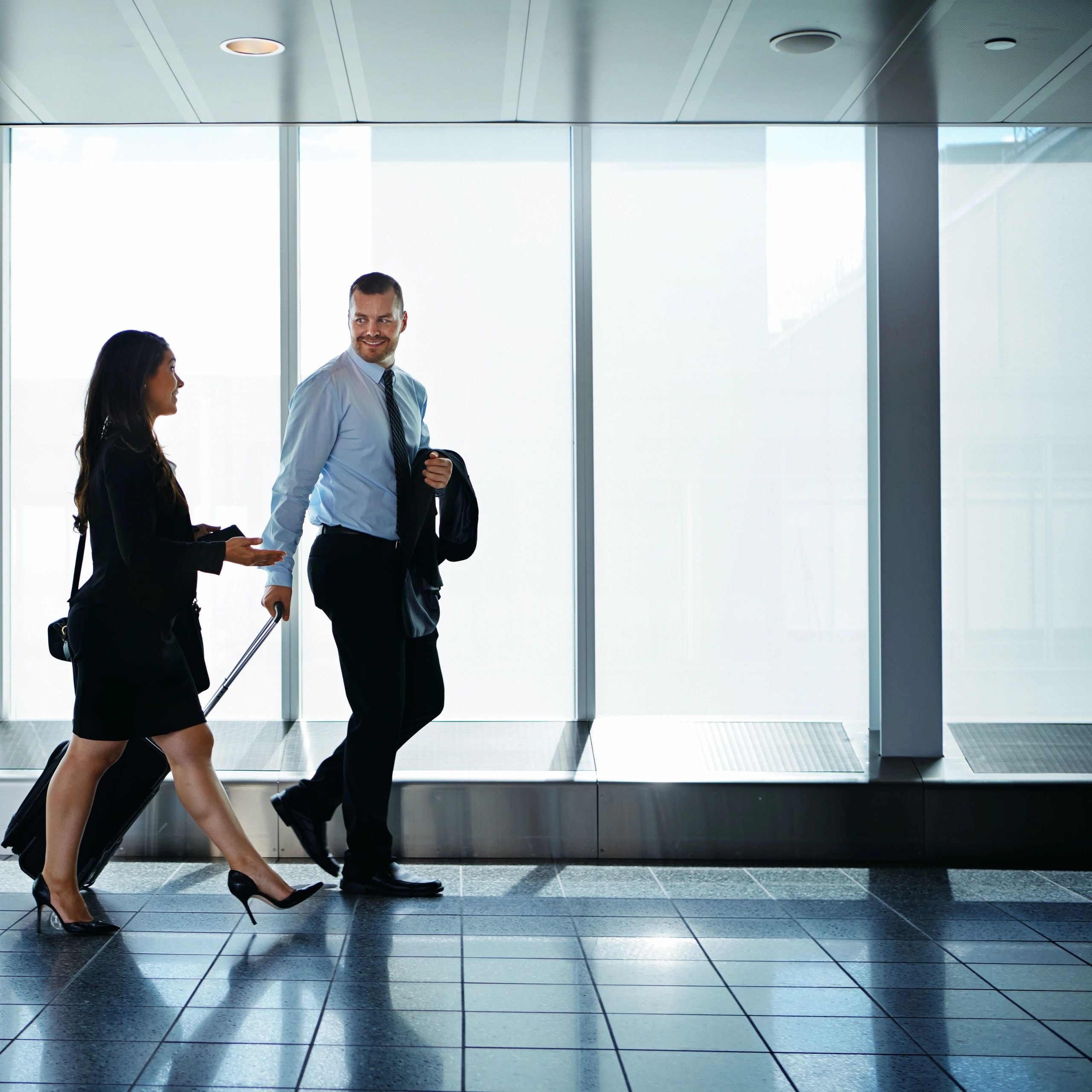 Two business professionals in a modern office corridor